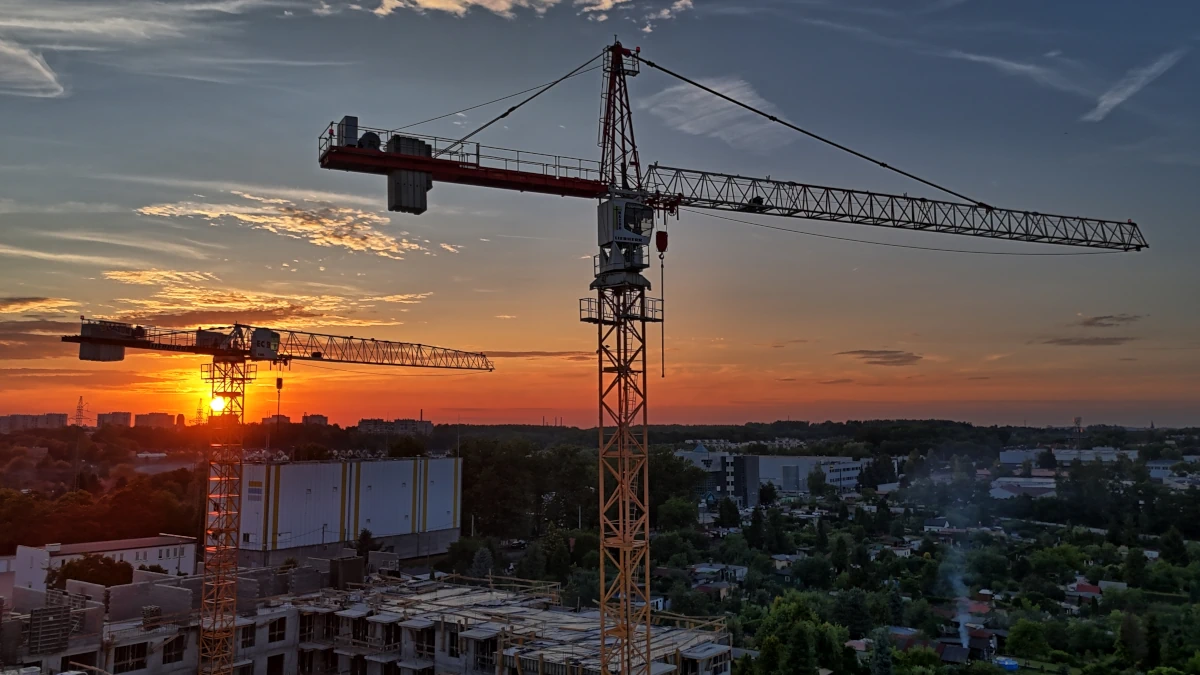 Współczesny żuraw wieżowy na tle miasta – symbol nowoczesnego budownictwa
