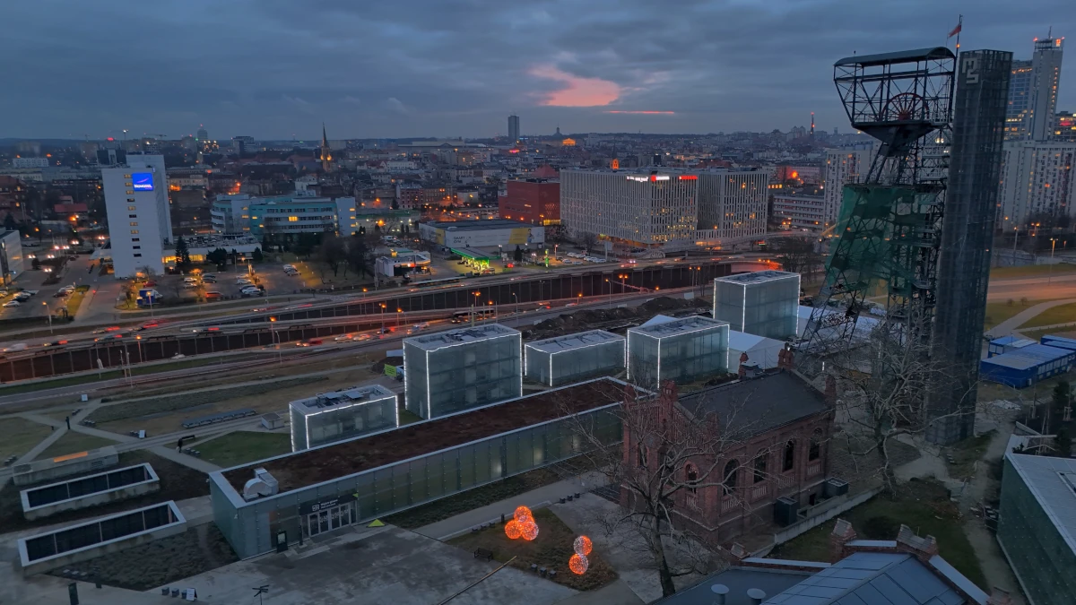 Muzeum Śląskie w Katowicach o zmierzchu – przeszklone bryły doświetlające podziemne galerie oraz wieża szybu kopalnianego