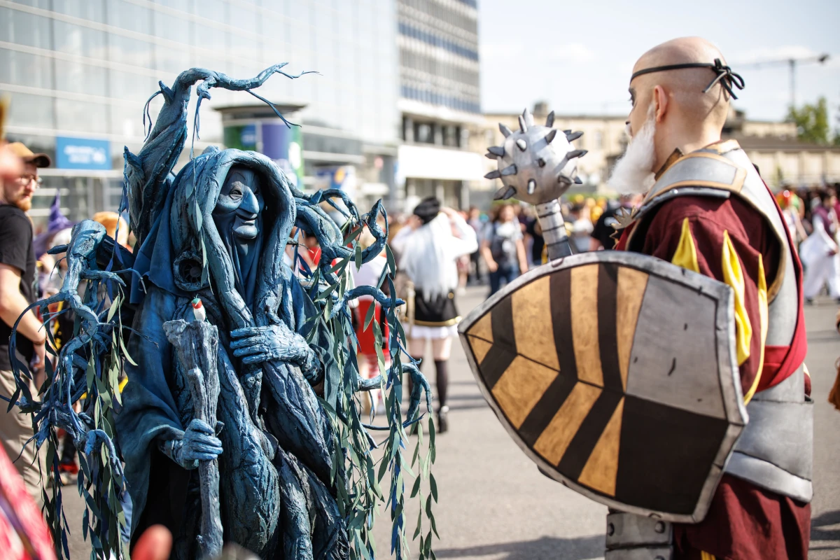 Dwie osoby w rozbudowanych kostiumach fantasy rozmawiające na terenie festiwalu
