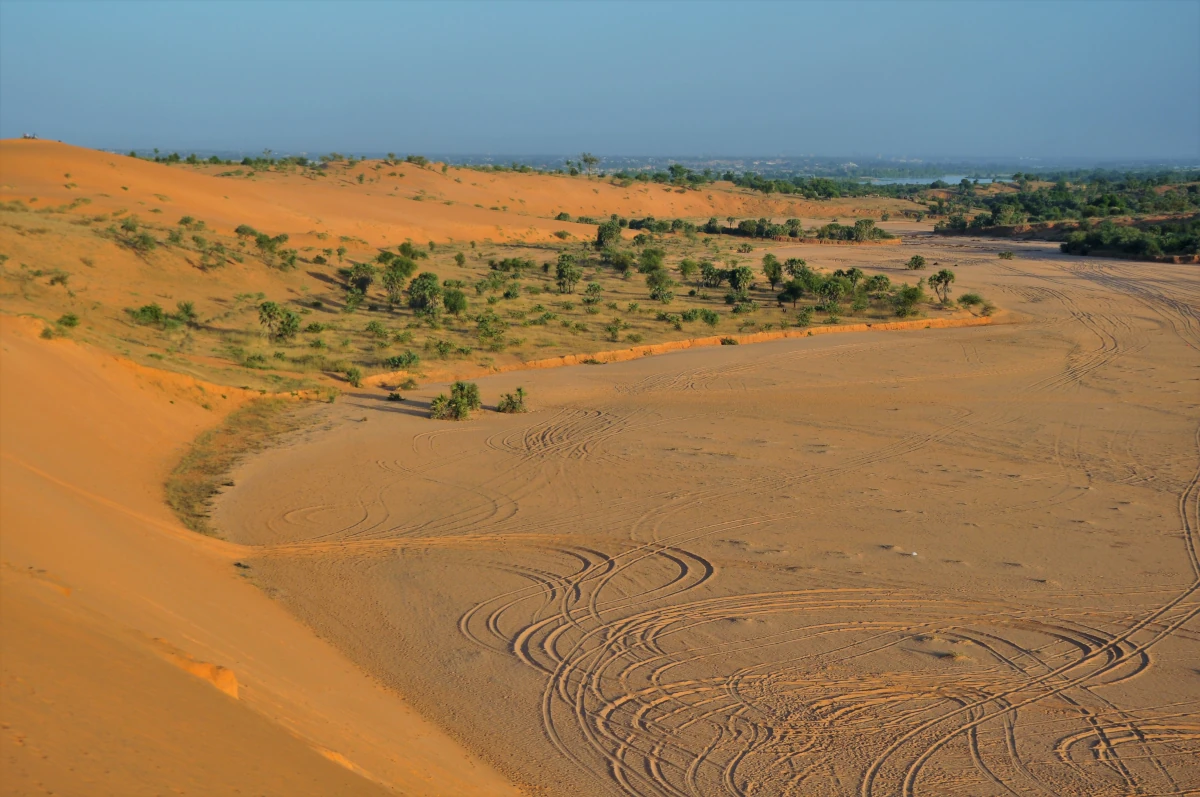 Pomarańczowe wydmy, piaszczyste obniżenie terenu i rozproszona roślinność na zachód od Niamey.