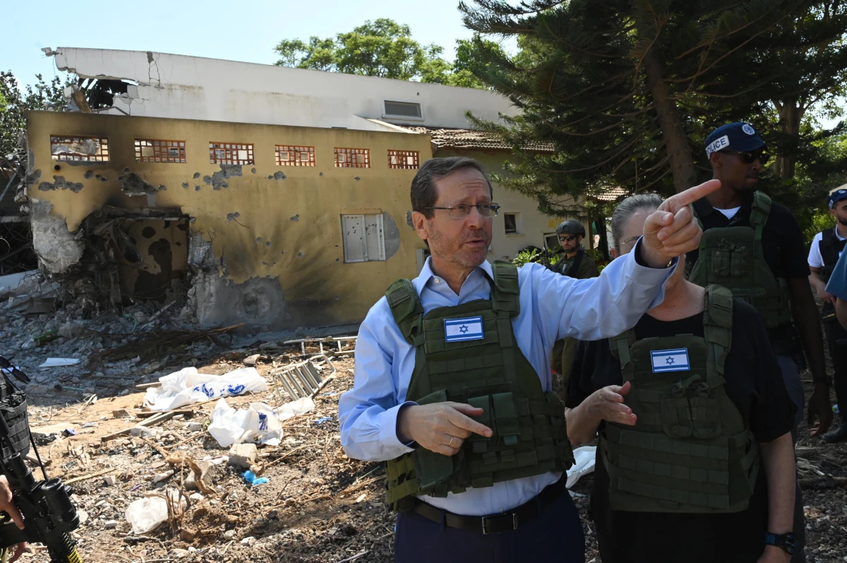 Prezydent Izraela Isaac Herzog w kamizelce ochronnej podczas wizyty w zniszczonym kibucu Be’eri
