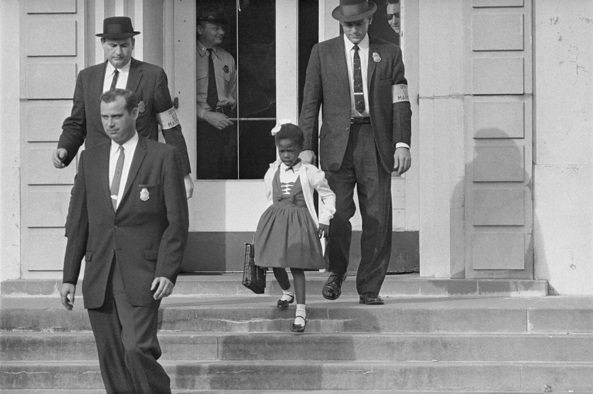 Ruby Bridges schodząca po schodach szkoły w towarzystwie funkcjonariuszy federalnych