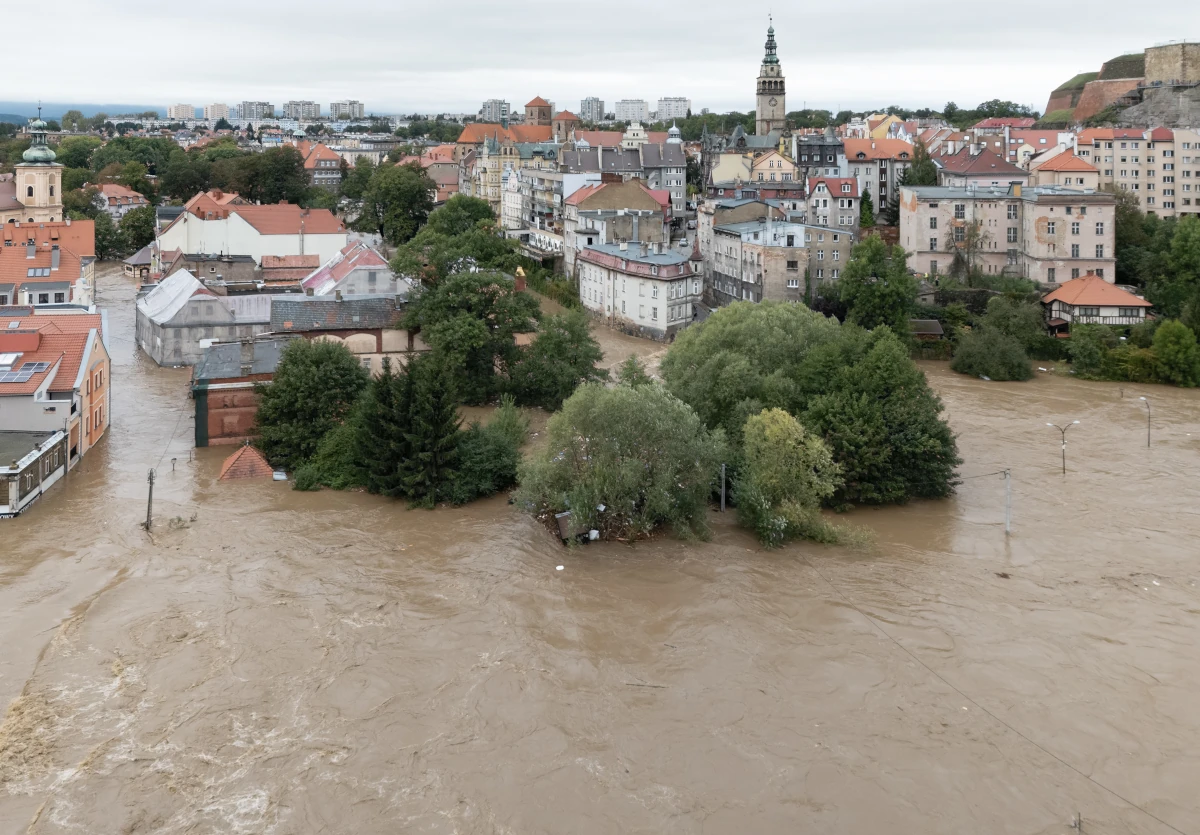 Rozlana woda powodziowa w centrum Kłodzka, z wieżą ratusza i twierdzą w tle